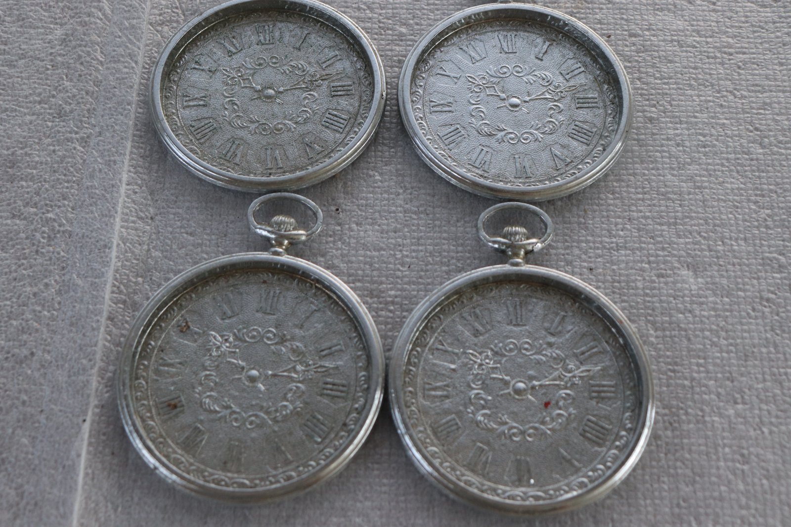 Set of four silver-tone pocket-watch style metal coasters with Roman numerals (Lot 220)