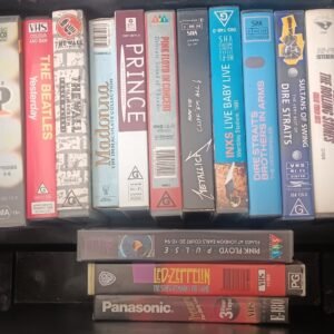 collection of vintage VHS music tapes featuring Metallica, Pink Floyd, Queen, and The Beatles