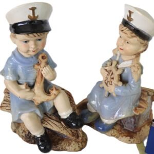 LOT 261 - Pair of sailor children figurines – anchor & ship’s wheel
