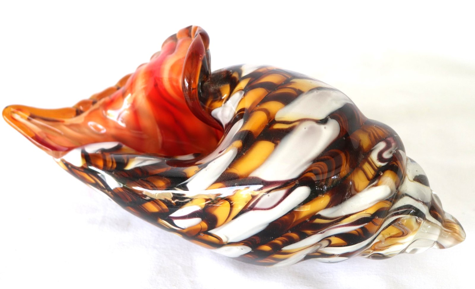 Side view of blown glass conch shell showing spattered swirl pattern