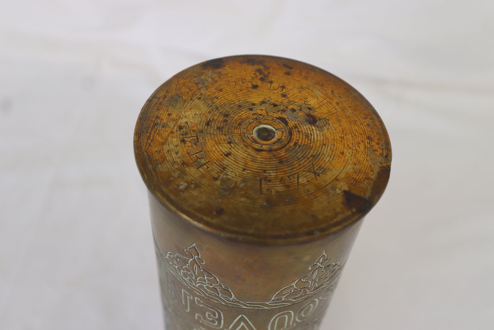 Base of brass shell casing showing headstamp markings on concentric rings