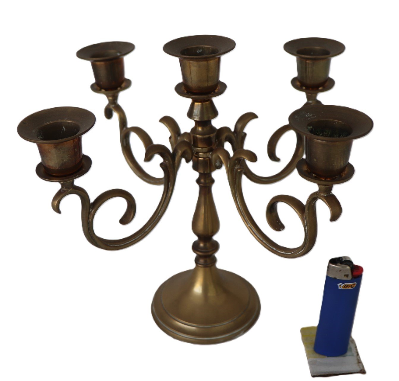 Vintage brass five-arm candelabra with ornate scrolling arms and aged patina