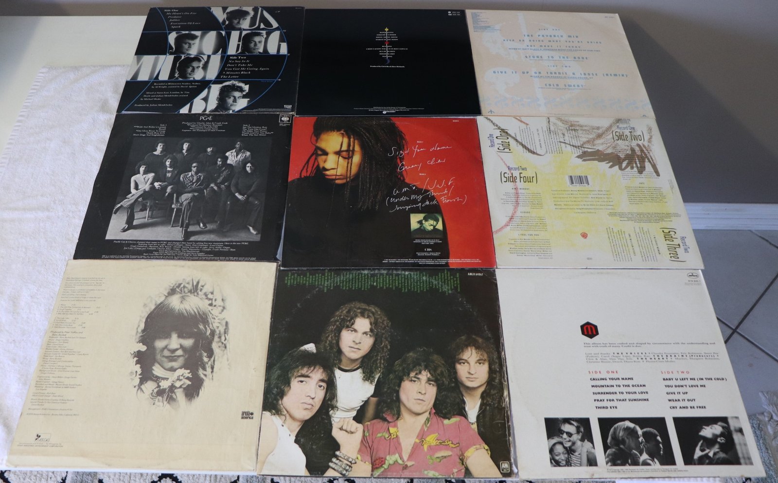 Back covers of nine assorted vinyl albums showing track listings and artist photos