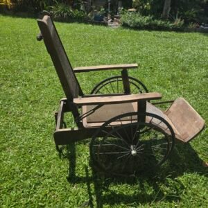 Early wooden wheelchair with wicker backrest and spoked wheels