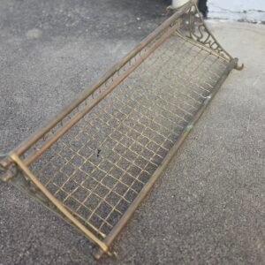 Vintage brass tone wall shelf with ornate cast ends and wire mesh base
